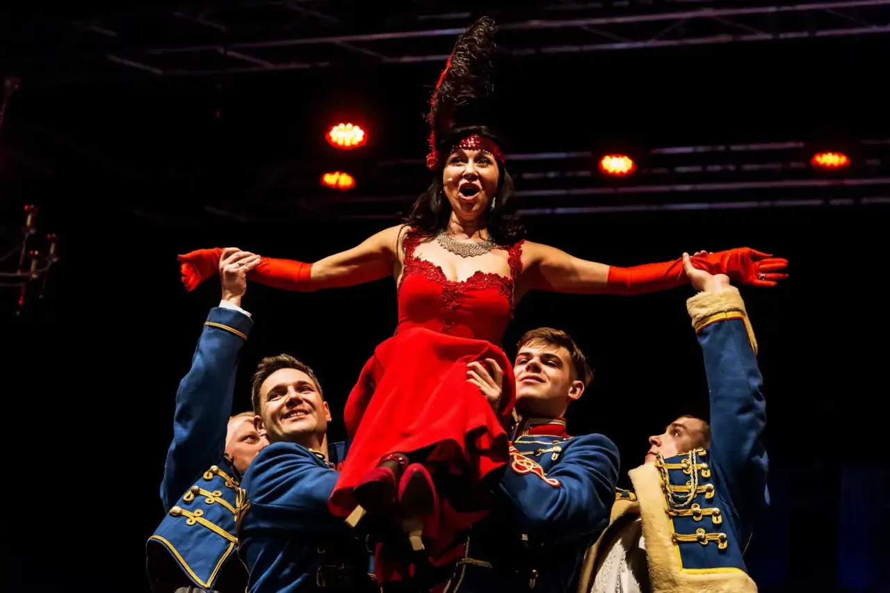 Wspaniała diva w czerwonej sukni, unoszona przez tancerzy w mundurach. To właśnie jest **operetka co to** za widowisko!