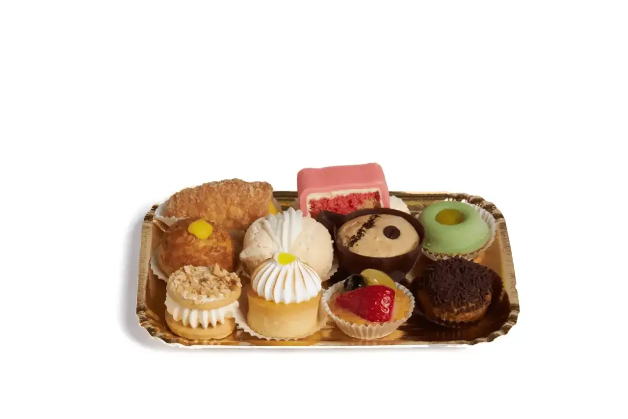 Vassoio dorato con assortimento di pasticcini mignon: crostatine, bignè, dolcetti alla frutta e al cioccolato. Idee per ogni occasione.