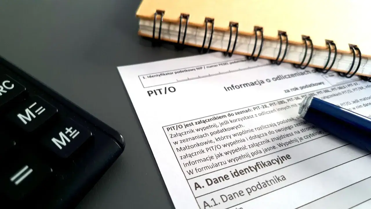 Kalkulator, notatnik i formularz PIT/O. Przygotowanie do rozliczenia podatkowego, być może związany z emeryturą w Polsce.