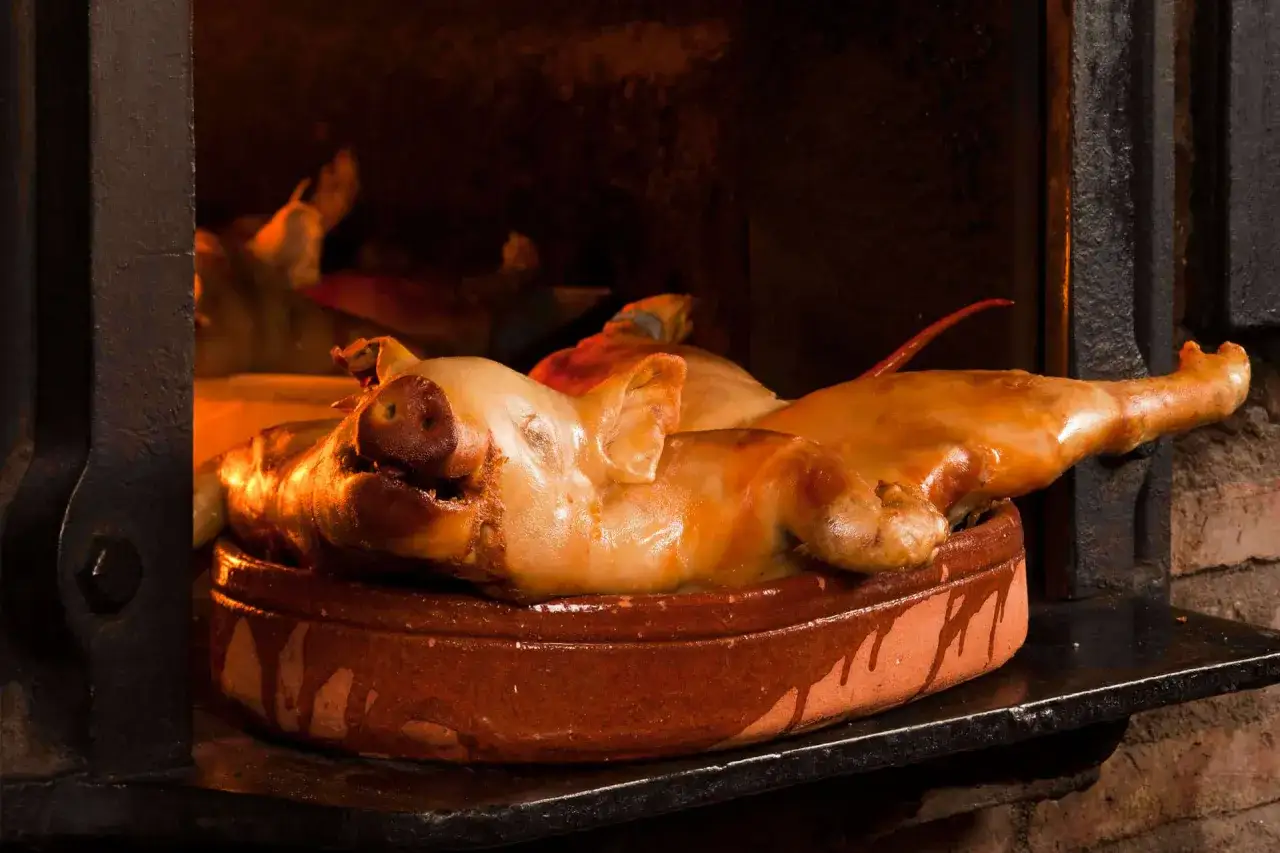 Cochinillo asado en horno de leña, un manjar imprescindible que comer en Segovia.