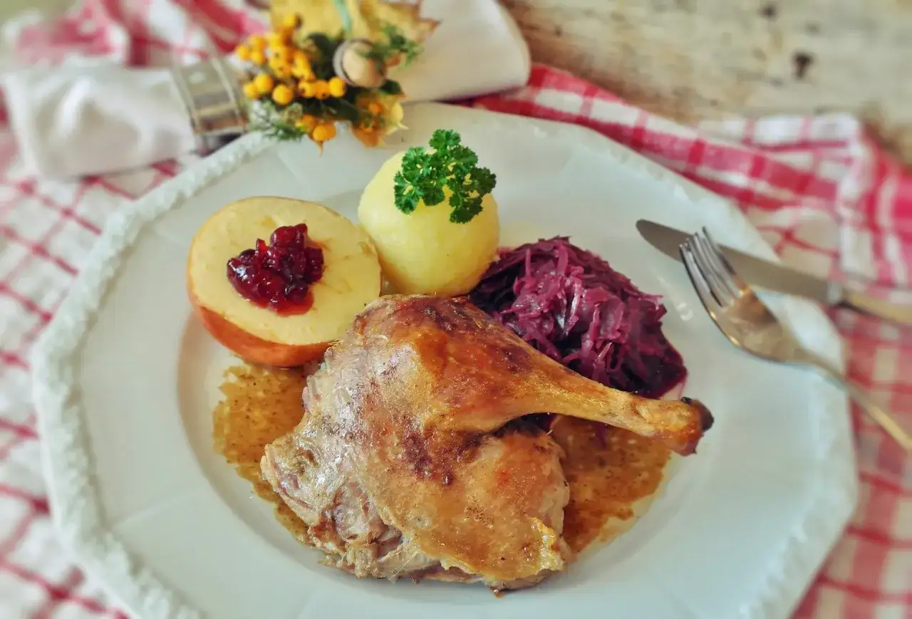 Pieczona kaczka z jabłkiem i czerwoną kapustą, jak z przepisu babci. Pyszne danie na specjalną okazję.