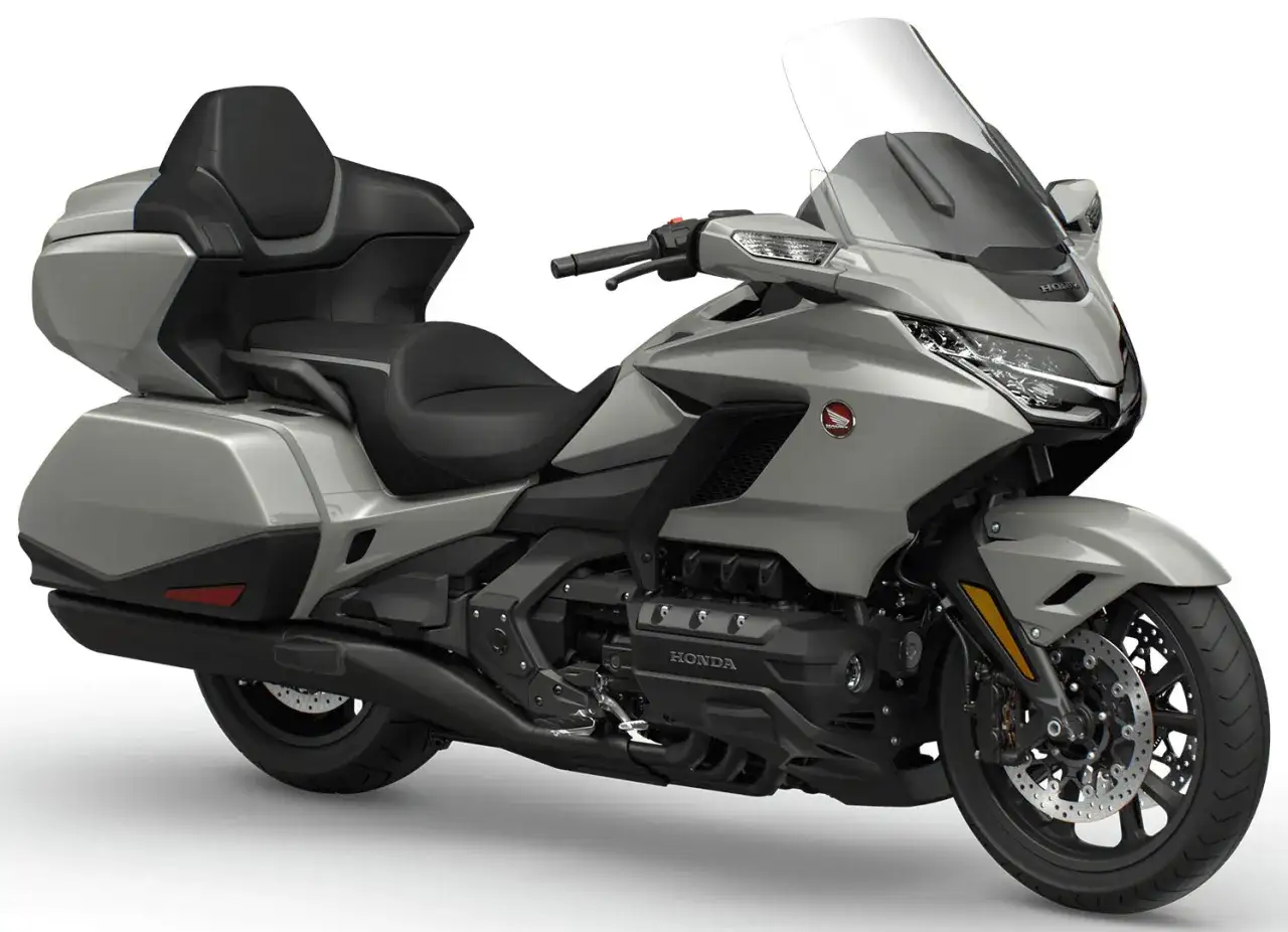 Srebrny motocykl Honda Goldwing z wygodnym siedzeniem i dużą szybą, gotowy na długie podróże.