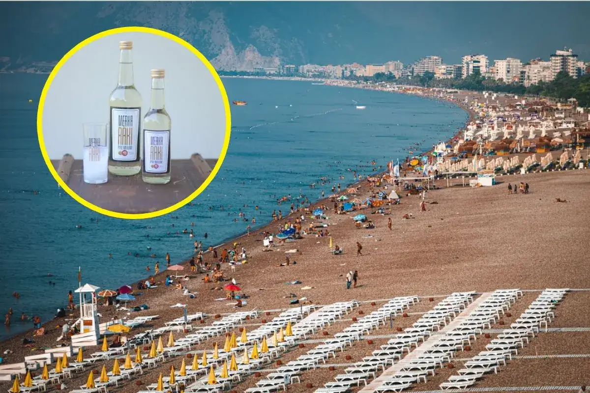 Wakacje all inclusive z alkoholem? Butelki rakı i szklanka na tle zatłoczonej plaży z turystami.