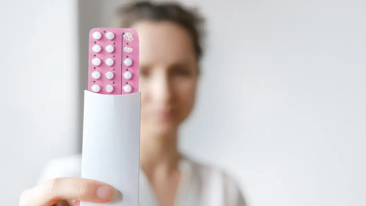 Frau hält eine Blisterpackung mit Pillen. Eine östrogenfreie Pille kann eine Option für Frauen sein, die empfindlich auf Östrogen reagieren.