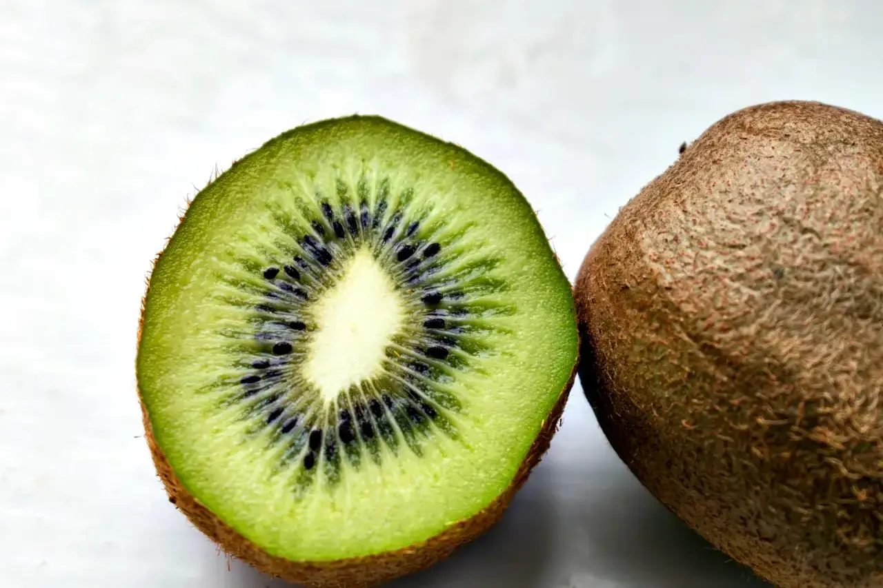 Przekrojone kiwi i całe owoc. Czy pies może jeść kiwi? Tak, ale w małych ilościach.