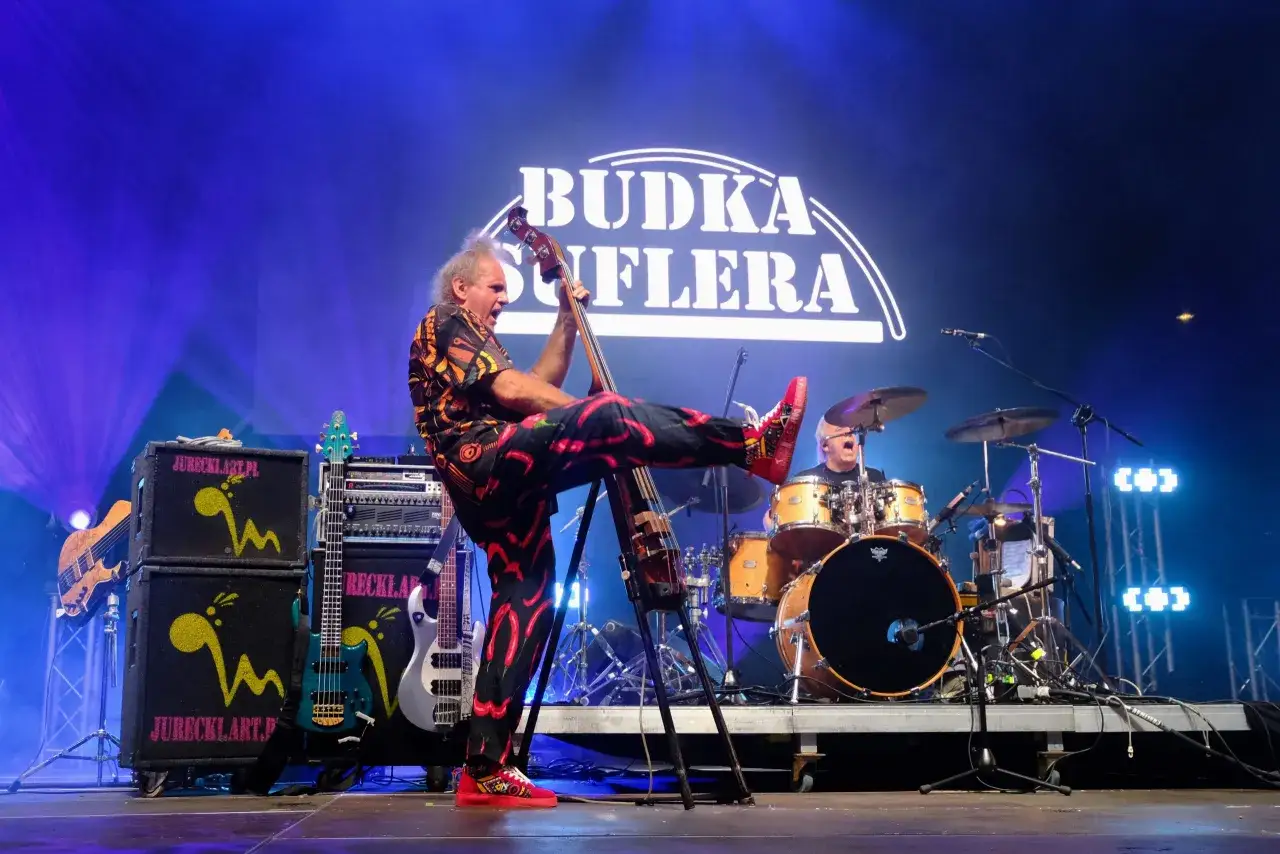 Budka Suflera na koncercie. Wokalista z basem, perkusista w tle. Energetyczne utwory zespołu.