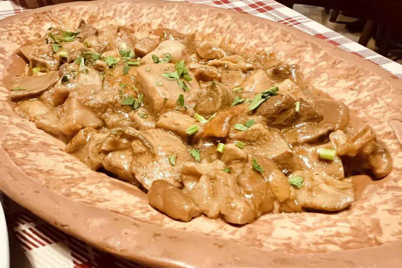 Un saporito stufato di funghi, uno dei piatti tipici di Arezzo, servito in un piatto di terracotta.