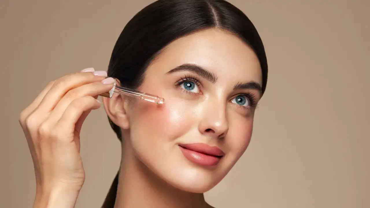 Frau trägt Vitamin C Serum für das Gesicht auf. Strahlende Haut dank der Kraft von Vitamin C.