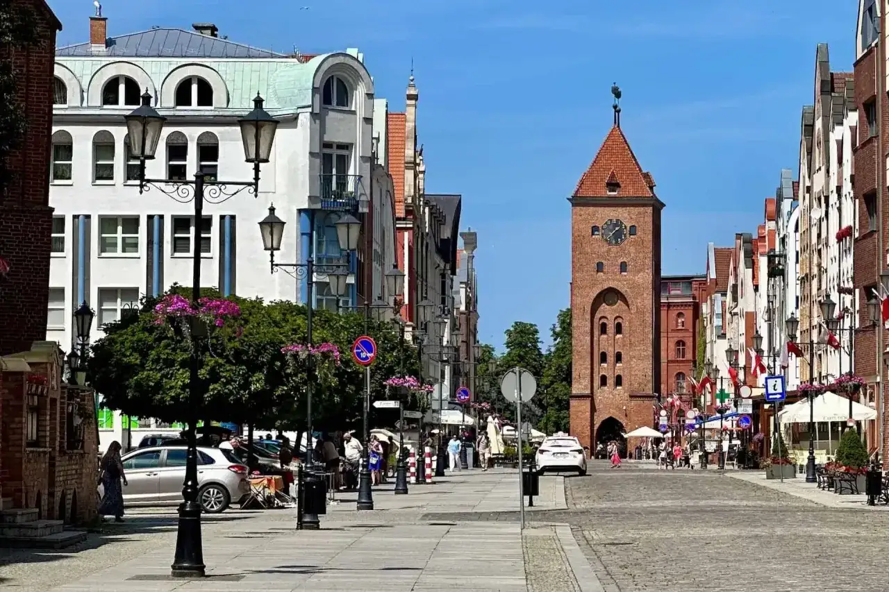 Ulica Starego Miasta w Elblągu z charakterystyczną Bramą Targową. Idealne miejsce, by poczuć atmosferę miasta i zobaczyć, co zobaczyć w Elblągu.