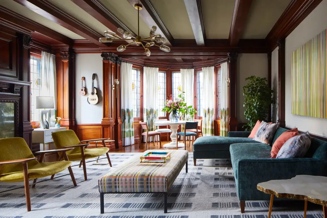 Gemütliches Wohnzimmer mit Holzakzenten, zwei Gitarren an der Wand und einem modernen Sofa. Verschiedene einrichtungsstile namen wie Mid-Century und Bohemian sind erkennbar.