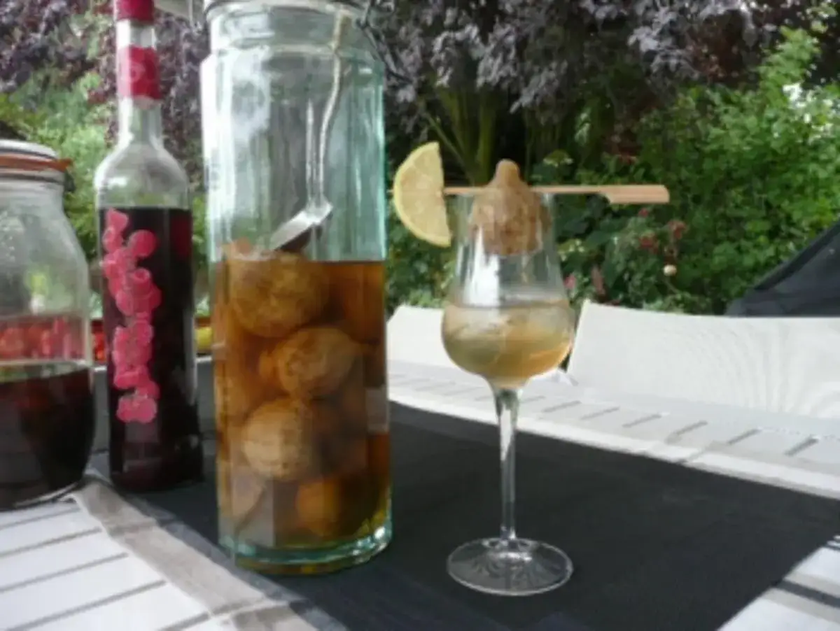 Glas mit Walnusslik&ouml;r, ein Glas mit Himbeerlik&ouml;r und ein Glas mit einem Drink, der zeigt, wie man schnaps selber machen mit wodka kann.
