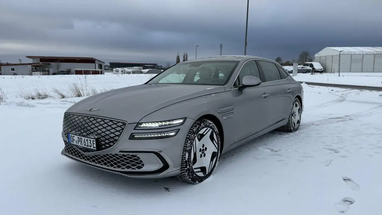 Gr&aring; Genesis G80 Sverige redo f&ouml;r vinterv&auml;glag. Bilen st&aring;r parkerad i sn&ouml; med en molnig himmel.