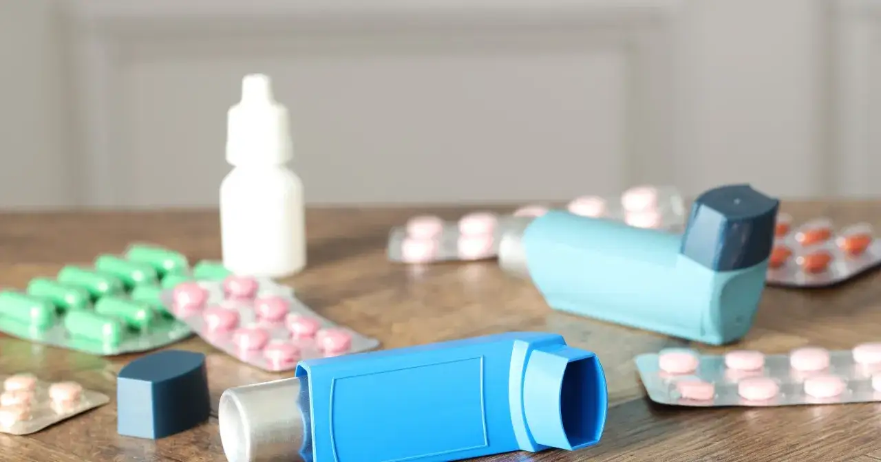 Dwa inhalatory i opakowania leków, w tym zielone kapsułki i różowe tabletki. To zestaw na astmę, czyli oxodil combo.