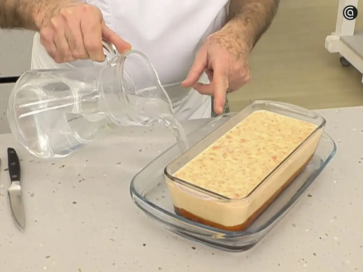 Vertiendo agua en un molde con flan de calabaza Arguiñano.