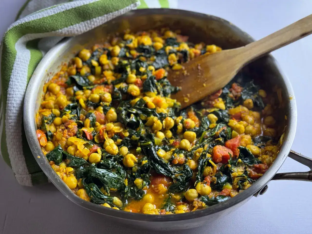 Herzhaftes Kichererbsen-Spinat-Curry in einer Pfanne, das zeigt, wozu Kurkuma passt: zu wärmenden, aromatischen Gerichten.