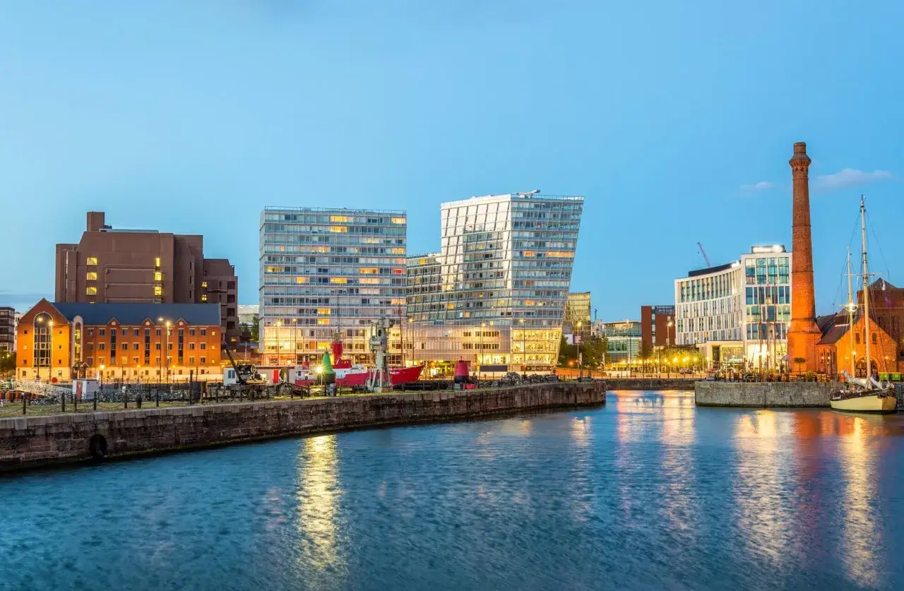Moderne Geb&auml;ude und ein alter Schornstein pr&auml;gen die Skyline der Liverpool Stadt am Wasser.
