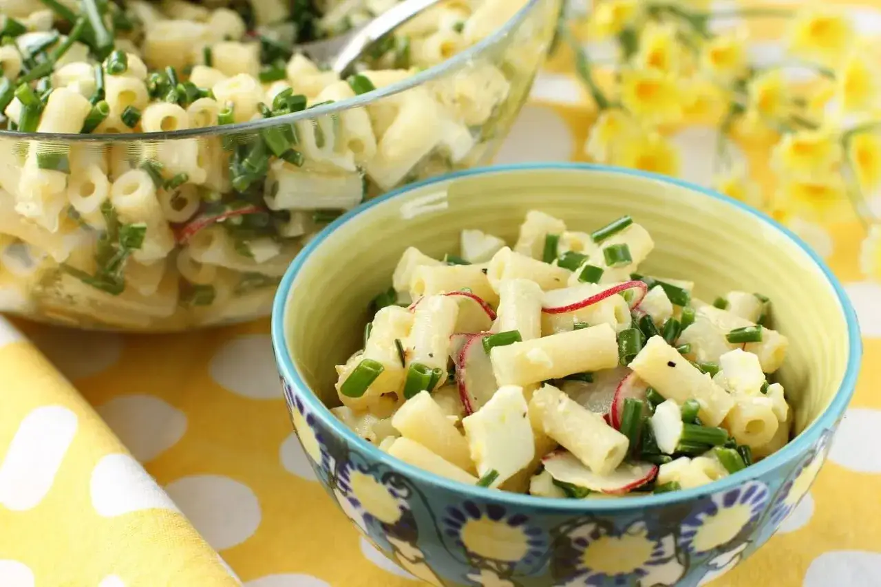Pyszna pasta z awokado, jajkiem i szczypiorkiem, podana w miseczce. Idealna na wiosenny posiłek.