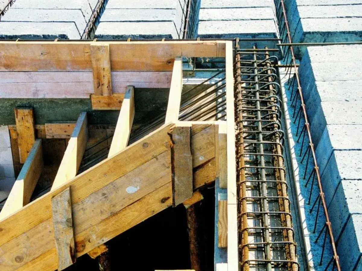 Szalunek i zbrojenie schodów betonowych. Widoczna grubość schodów betonowych, drewniane elementy szalunku i stalowe pręty.