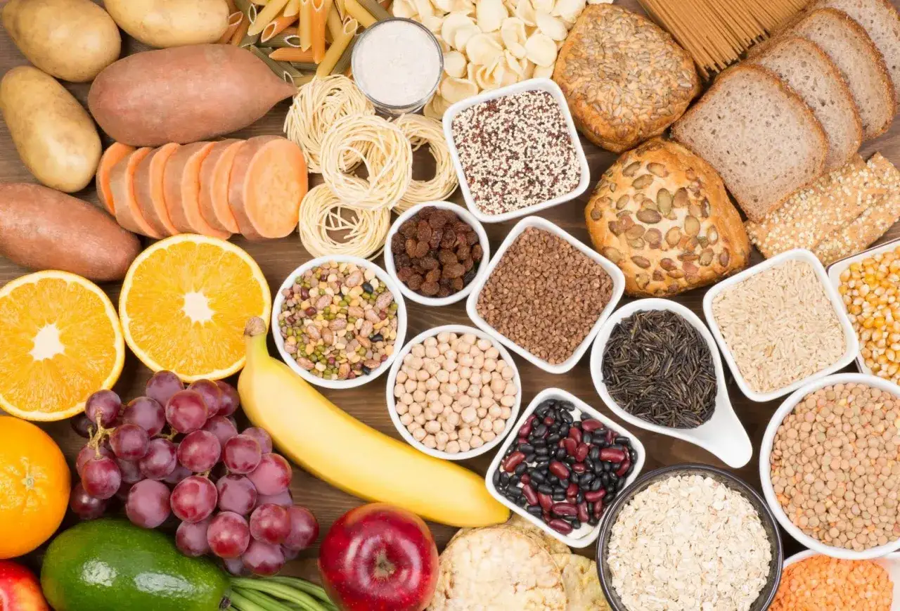 Węglowodany co to? Różnorodne źródła: ziemniaki, bataty, owoce (pomarańcze, banan, winogrona, jabłko), pieczywo, makarony, ryż, kasze, fasole, soczewica, płatki owsiane.