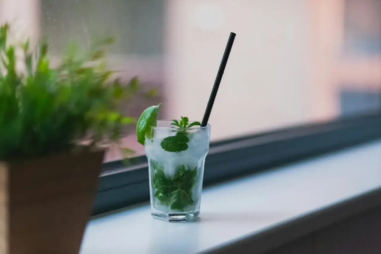 Orzeźwiający mojito przepis: szklanka z lodem, miętą i limonką, gotowa do wypicia.