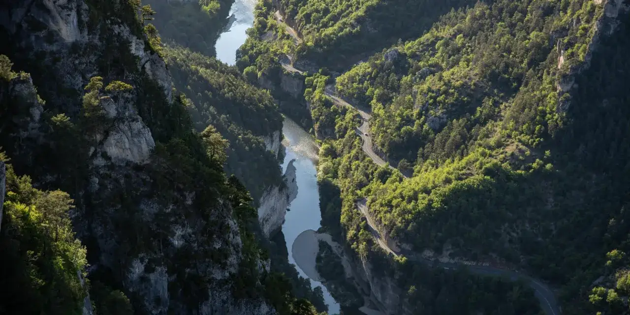 Vue a&eacute;rienne des Gorges du Tarn, une route sinueuse longeant la rivi&egrave;re. Id&eacute;al pour visiter les gorges du Tarn en 3 jours.