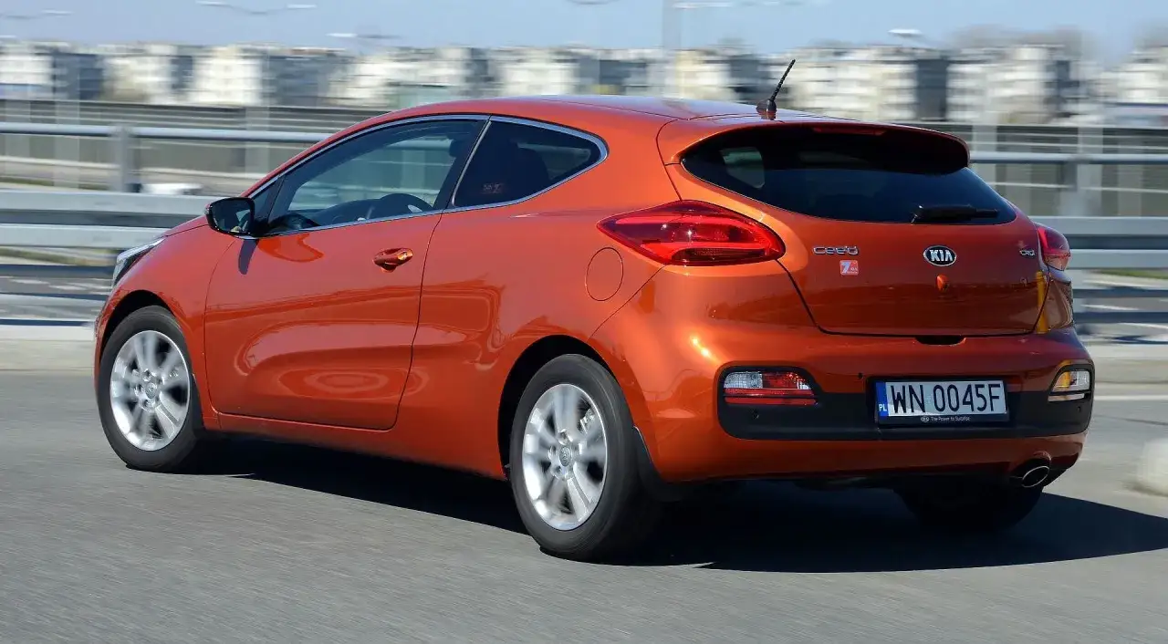 Pomarańczowa Kia Ceed 1.6 benzyna w ruchu miejskim.