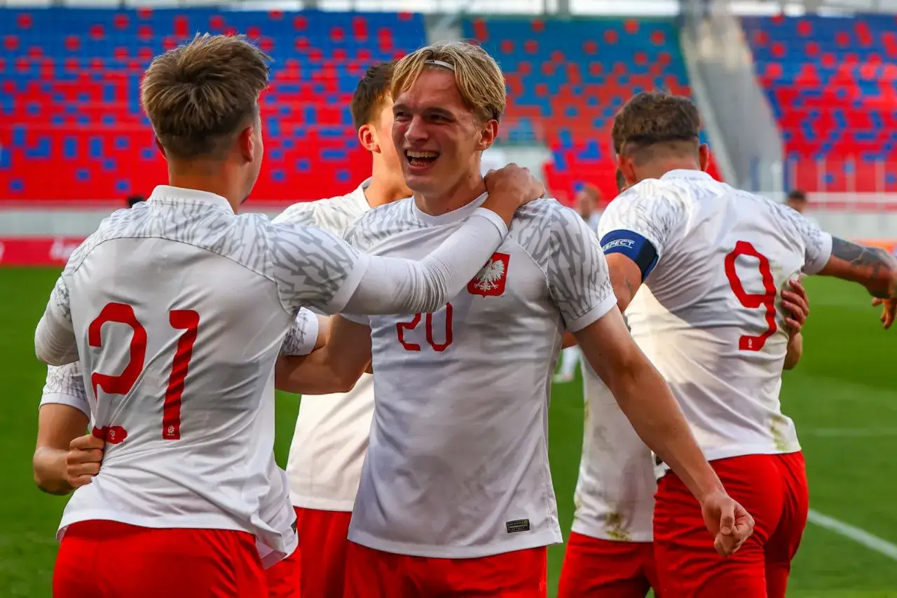 Piłkarze w białych strojach z orłem na piersiach, świętujący zwycięstwo. Stadion w barwach biało-czerwonych, jak polska Szwajcaria.