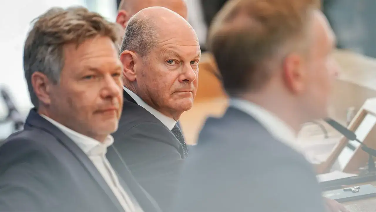Olaf Scholz und Robert Habeck blicken nachdenklich, während die Debatte über den Ende der Ampelregierung tobt.