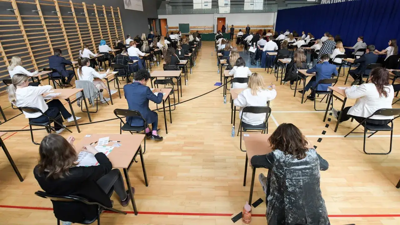 Uczniowie piszą egzamin w sali gimnastycznej. Czy egzaminy próbne są obowiązkowe? To pytanie zadaje sobie wielu uczniów, siedząc w ławkach.