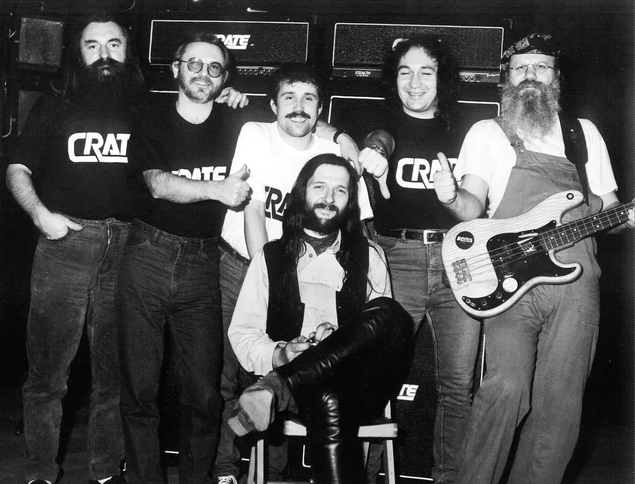 Zespół Dżem skład: Muzycy pozują do zdjęcia w czarnych koszulkach z logo CRAT. Jeden z nich trzyma gitarę basową.