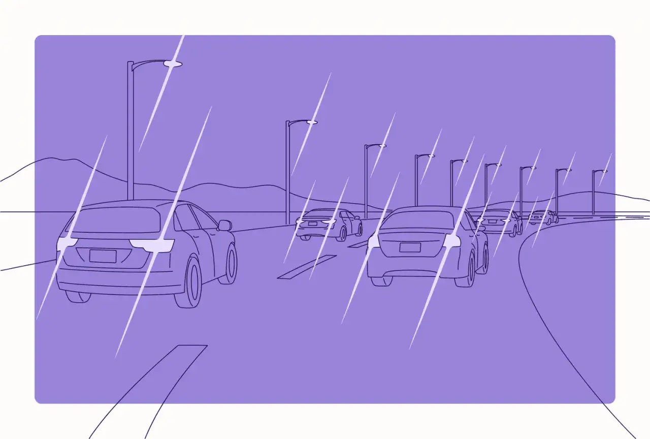 Strada con auto e lampioni, tutto sfocato e distorto, come vede un astigmatico.