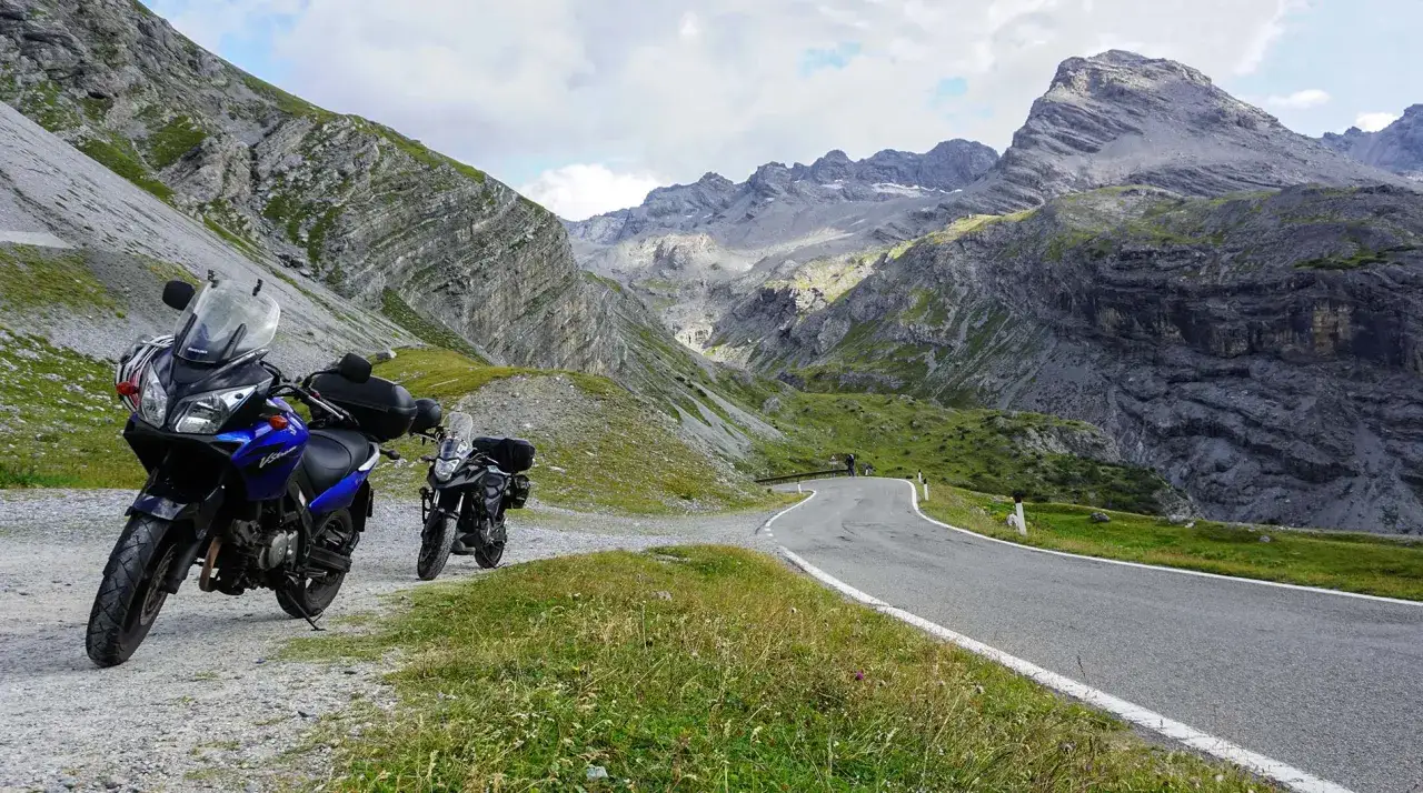 Motocykle na krętej drodze w g&oacute;rach. Czy dolomity to alpy? Te skaliste szczyty i zielone zbocza mogą wywołać takie pytanie.