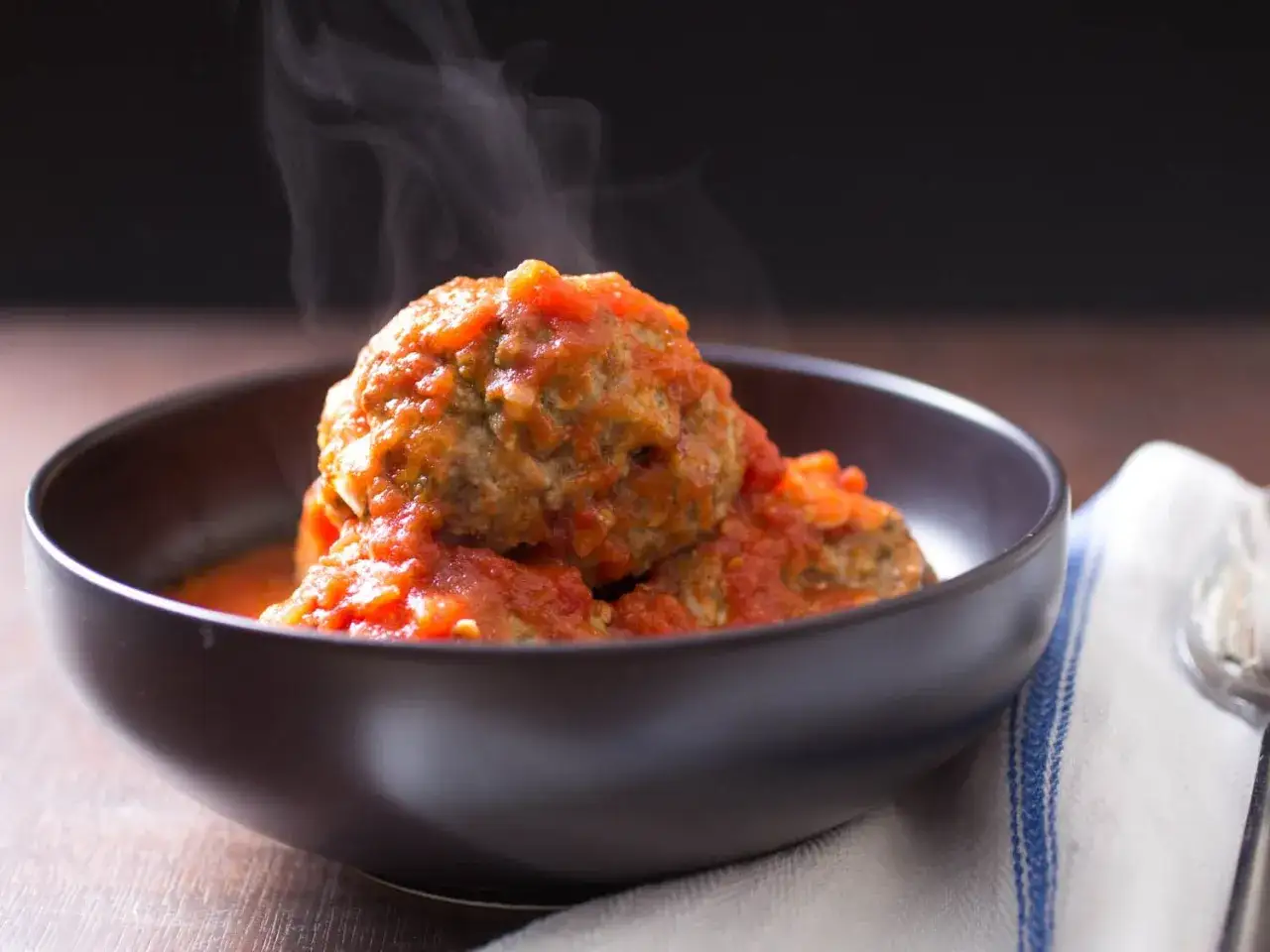 Hei&szlig;er Dampf steigt von saftigen Polpette in Tomatenso&szlig;e auf. Ein k&ouml;stliches polpette rezept, das zum Genie&szlig;en einl&auml;dt.
