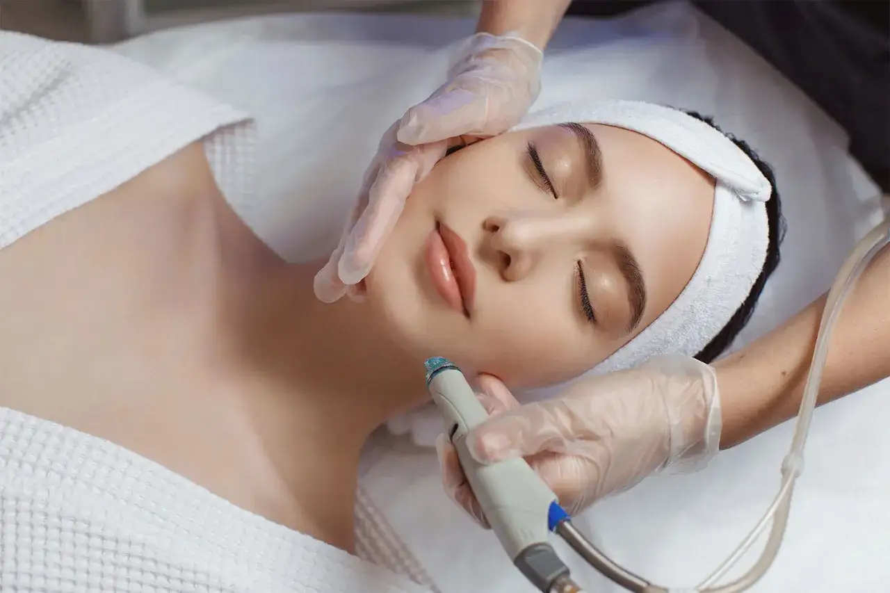 A woman enjoys a relaxing hydro infusion facial treatment, her skin glowing with hydration.