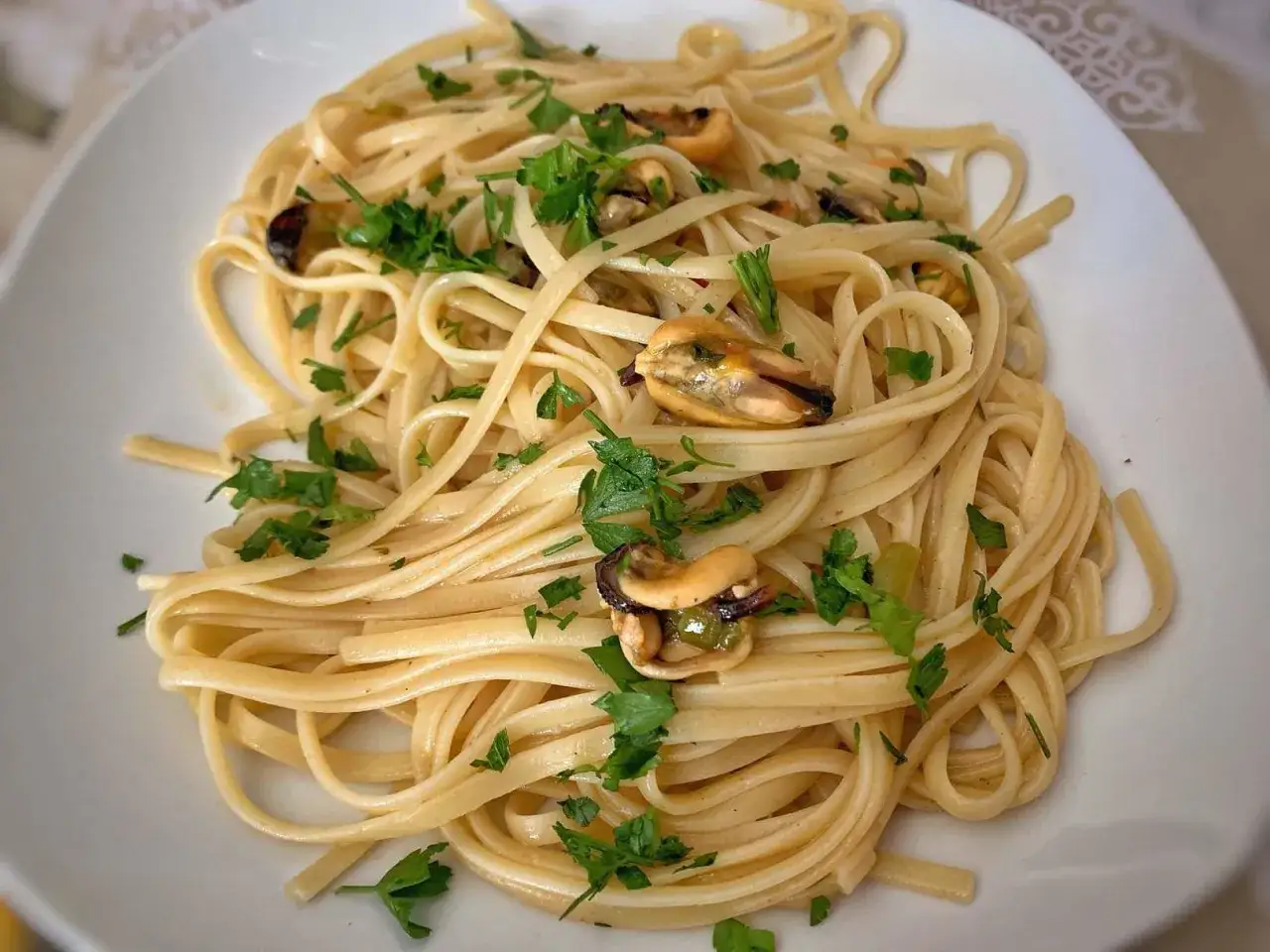 Spaghetti con le cozze in bianco, un piatto semplice e gustoso, con cozze succulente e prezzemolo fresco.