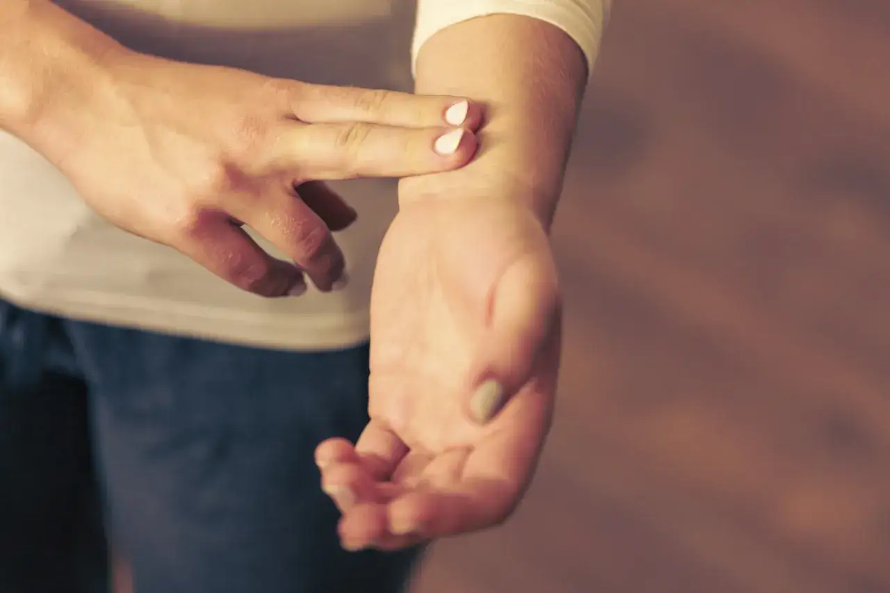 Person känner sin puls på handleden, en indikation på normal vilopuls.