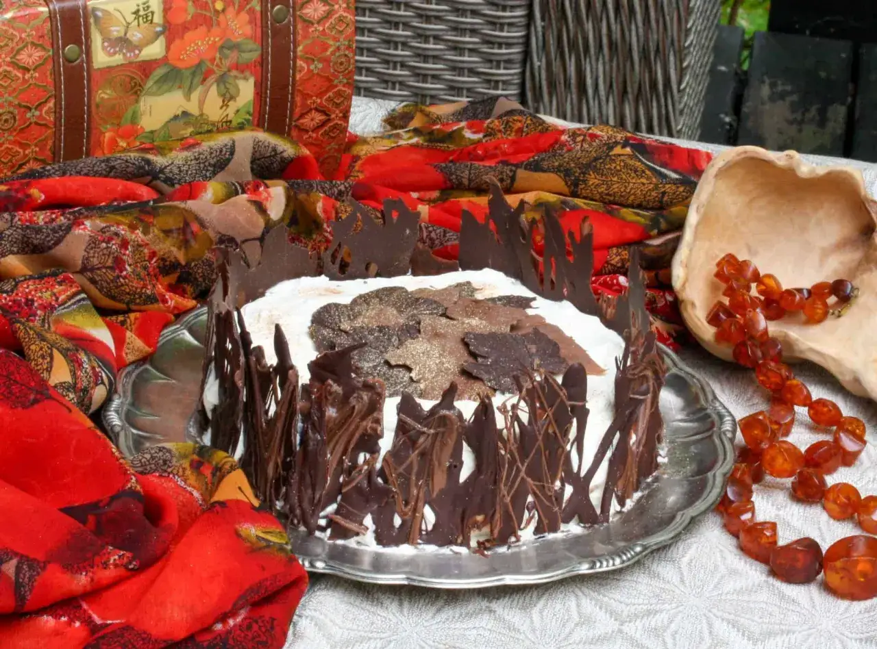 En vacker Schwarzwaldt&aring;rta med chokladdekorationer, perfekt f&ouml;r ett Schwarzwaldt&aring;rta recept. Omgiven av f&auml;rgglada tyger och b&auml;rnsten.