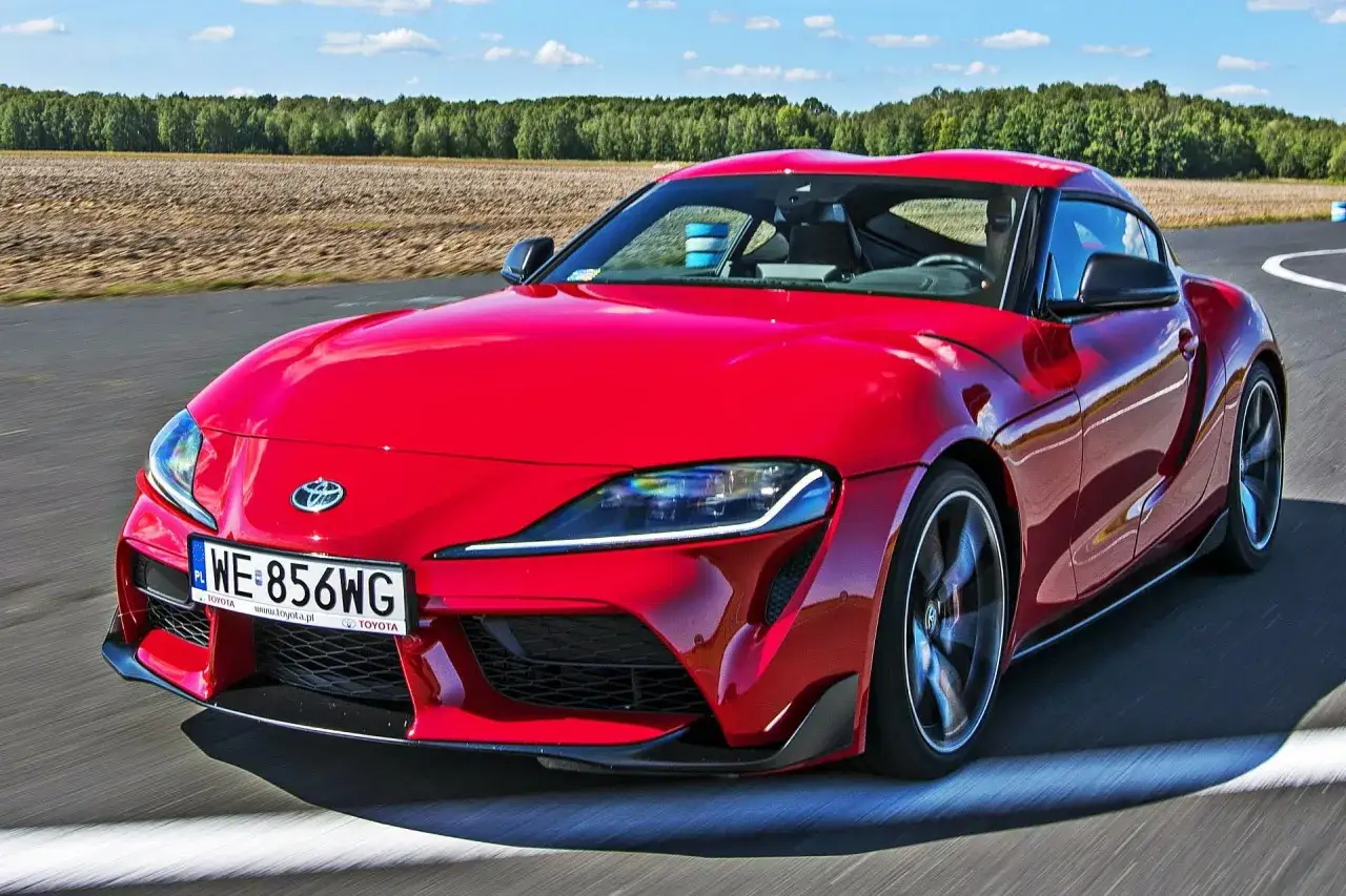 Czerwona Toyota Supra MK5 pędzi po torze. Zastanawiasz się, ile kosztuje Toyota Supra MK5? Ten sportowy samochód to marzenie wielu kierowców.