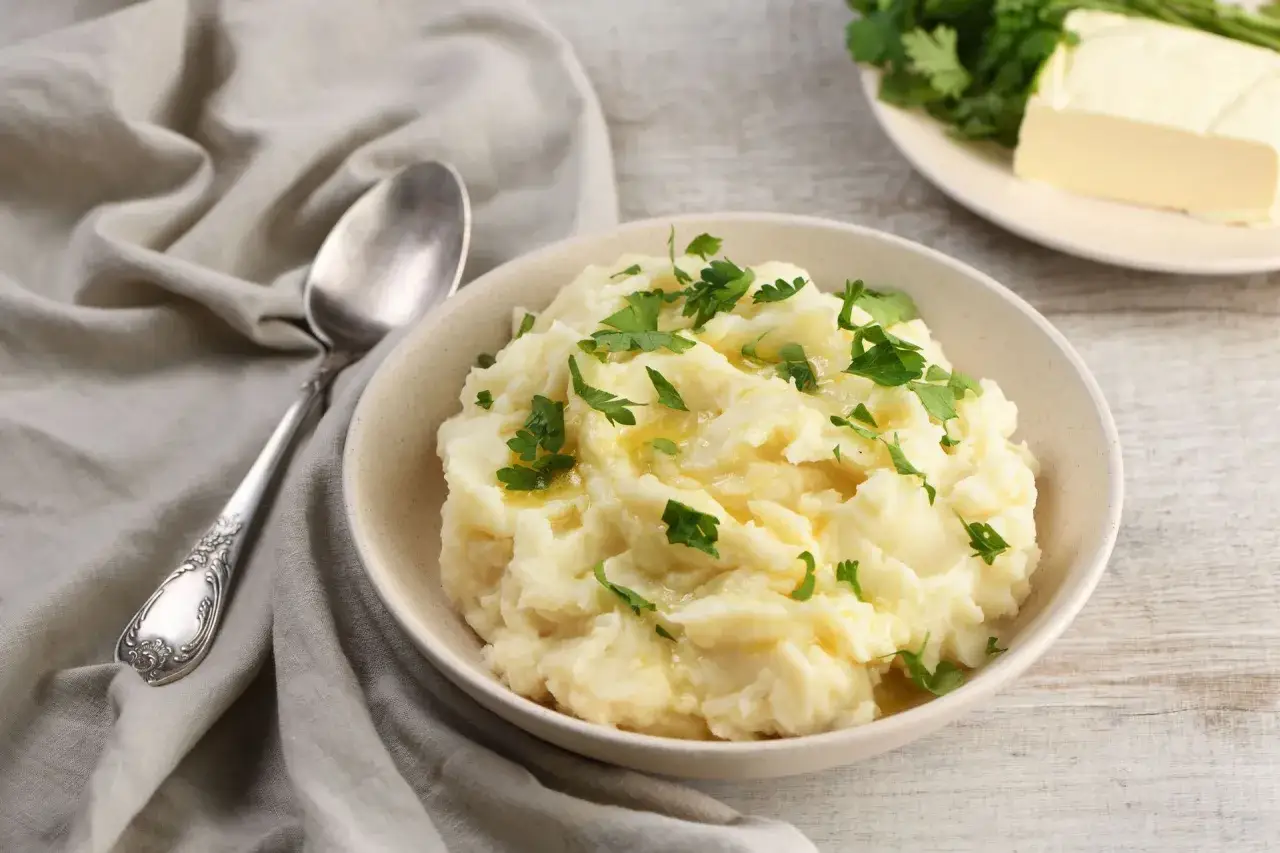 Puszyste puree z ziemniaków, polane masłem i posypane natką pietruszki. Idealne do obiadu, dowiedz się jak zrobić puree z ziemniaków.