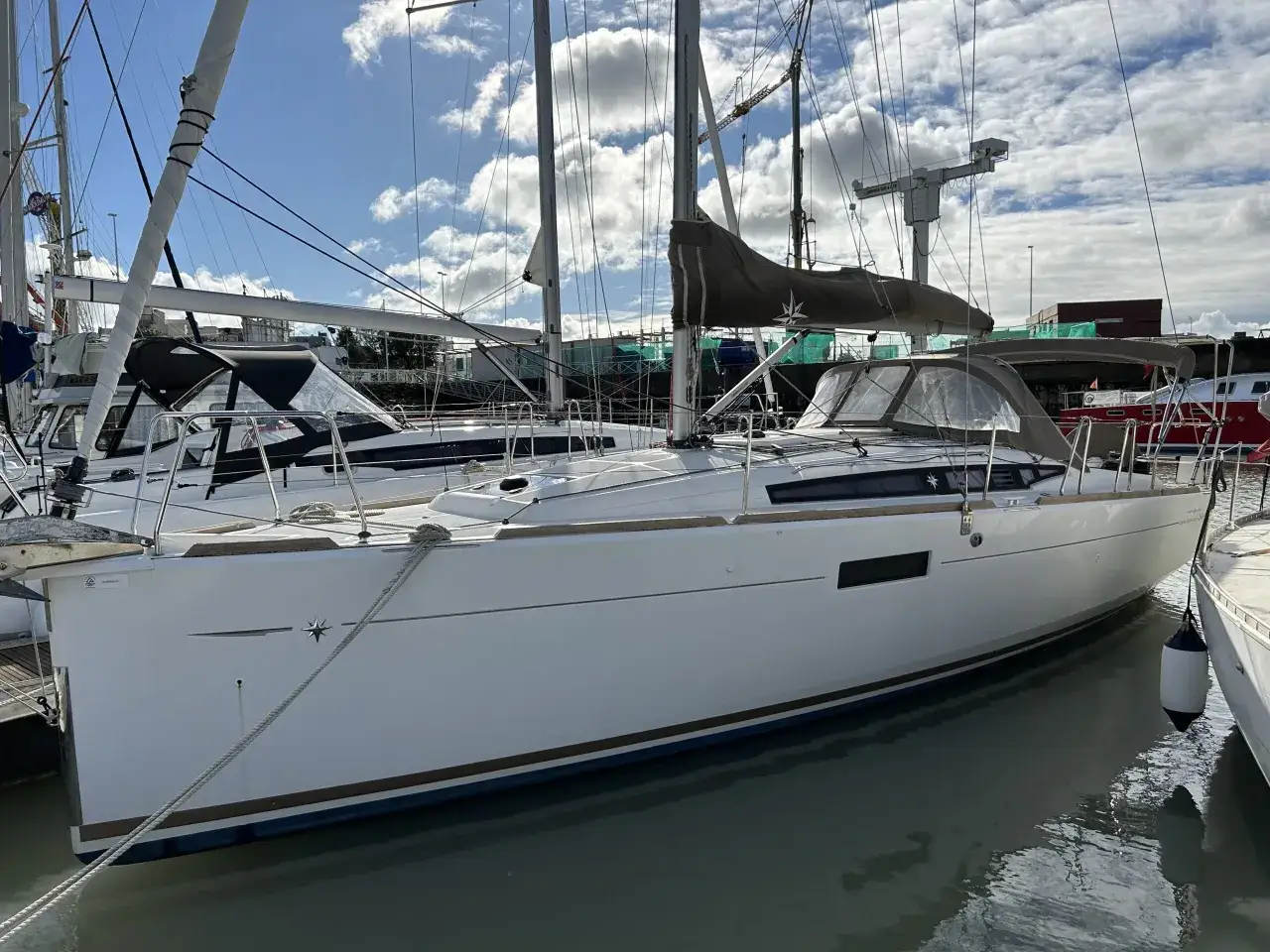 Un voilier blanc, un Sun Odyssey 349, est amarré dans un port. La fiche technique de ce bateau est disponible.
