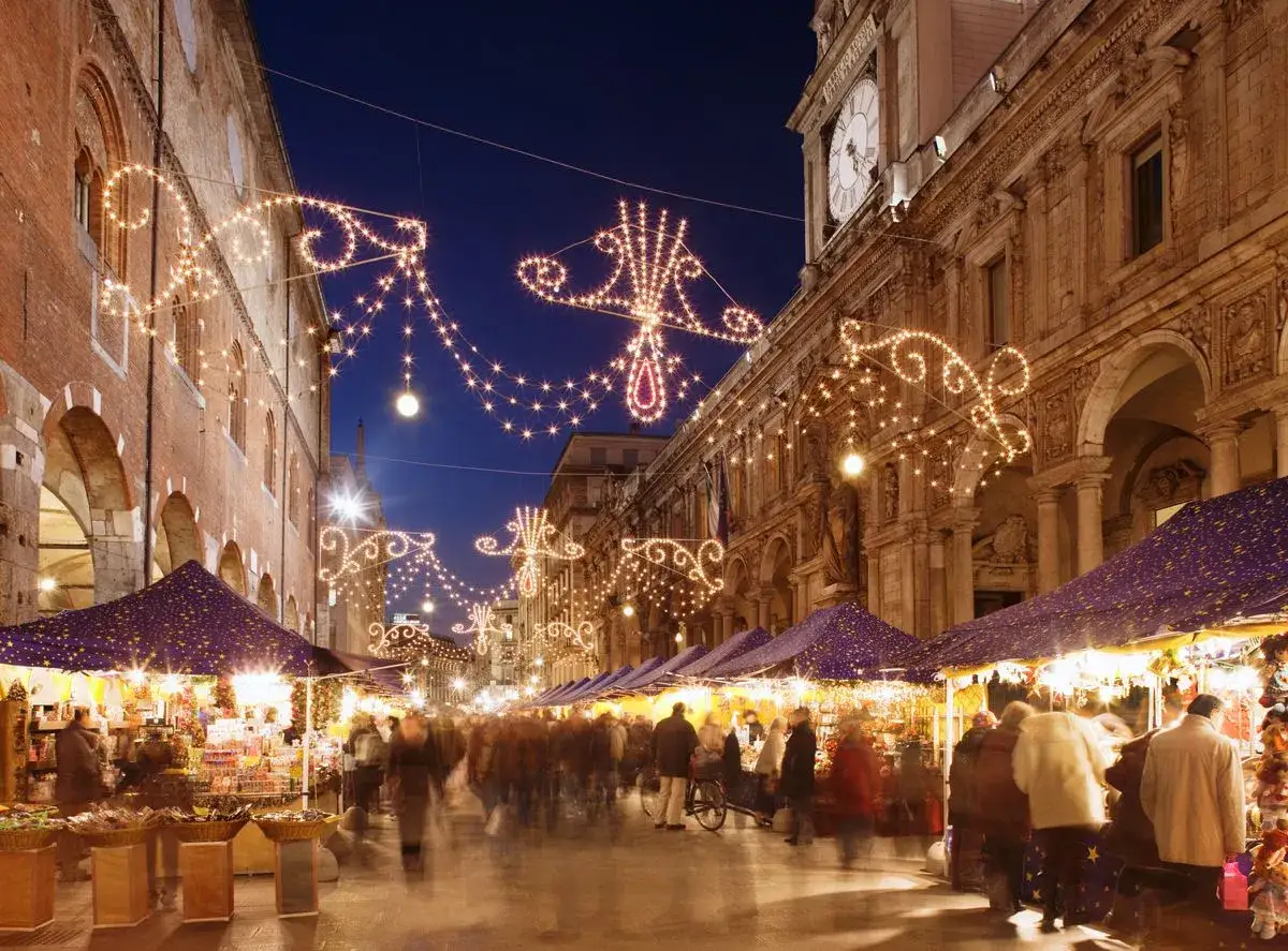 Luci scintillanti illuminano i mercatini di Natale nel Nord Italia. Bancarelle piene di doni e un'atmosfera magica.