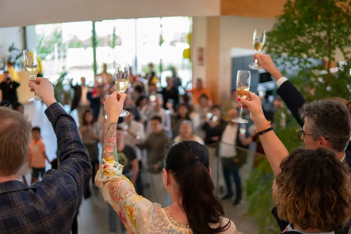 Gente brindando con copas de champ&aacute;n en un evento de aniversario de empresa.