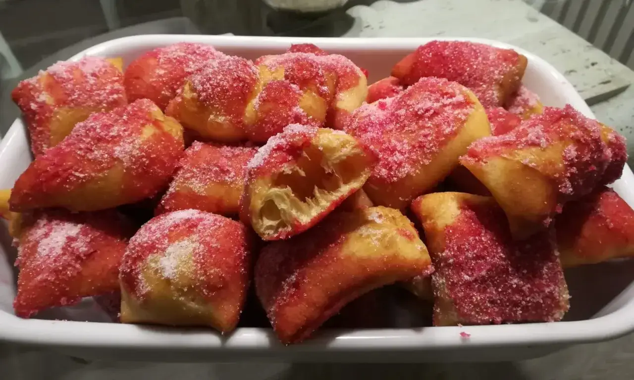 Castagnole marchigiane ricetta originale: dolcetti fritti dorati cosparsi di zucchero semolato e rosa.