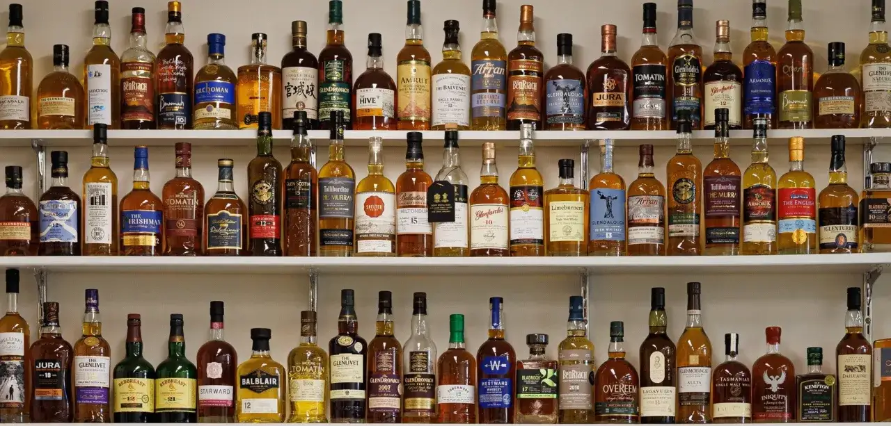 Regale voller Flaschen mit Whiskey oder Whisky, von bernsteinfarben bis tiefbraun.