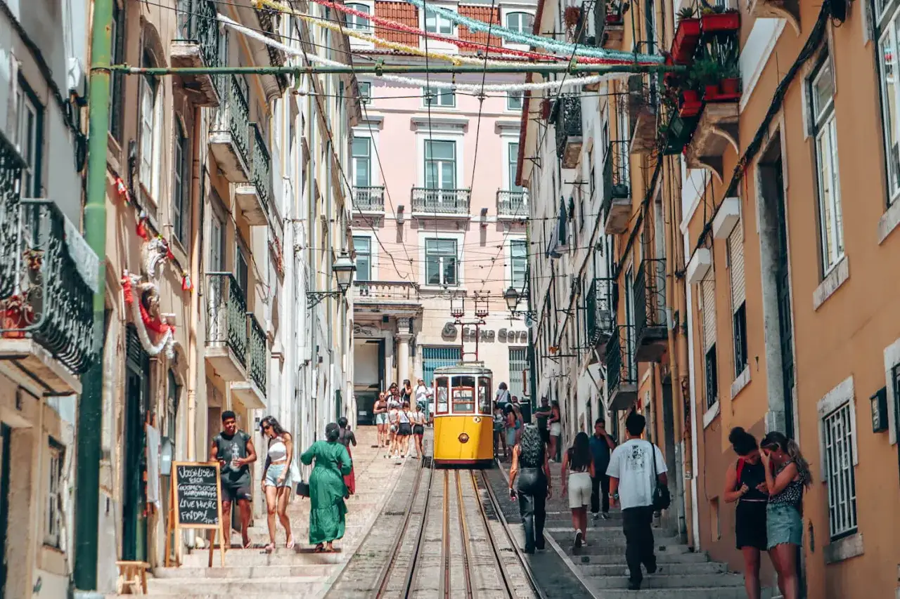 Gula spårvagnar klättrar uppför branta kullerstensgator i Lissabon, kantade av färgglada hus och folk som njuter av lissabon shopping.