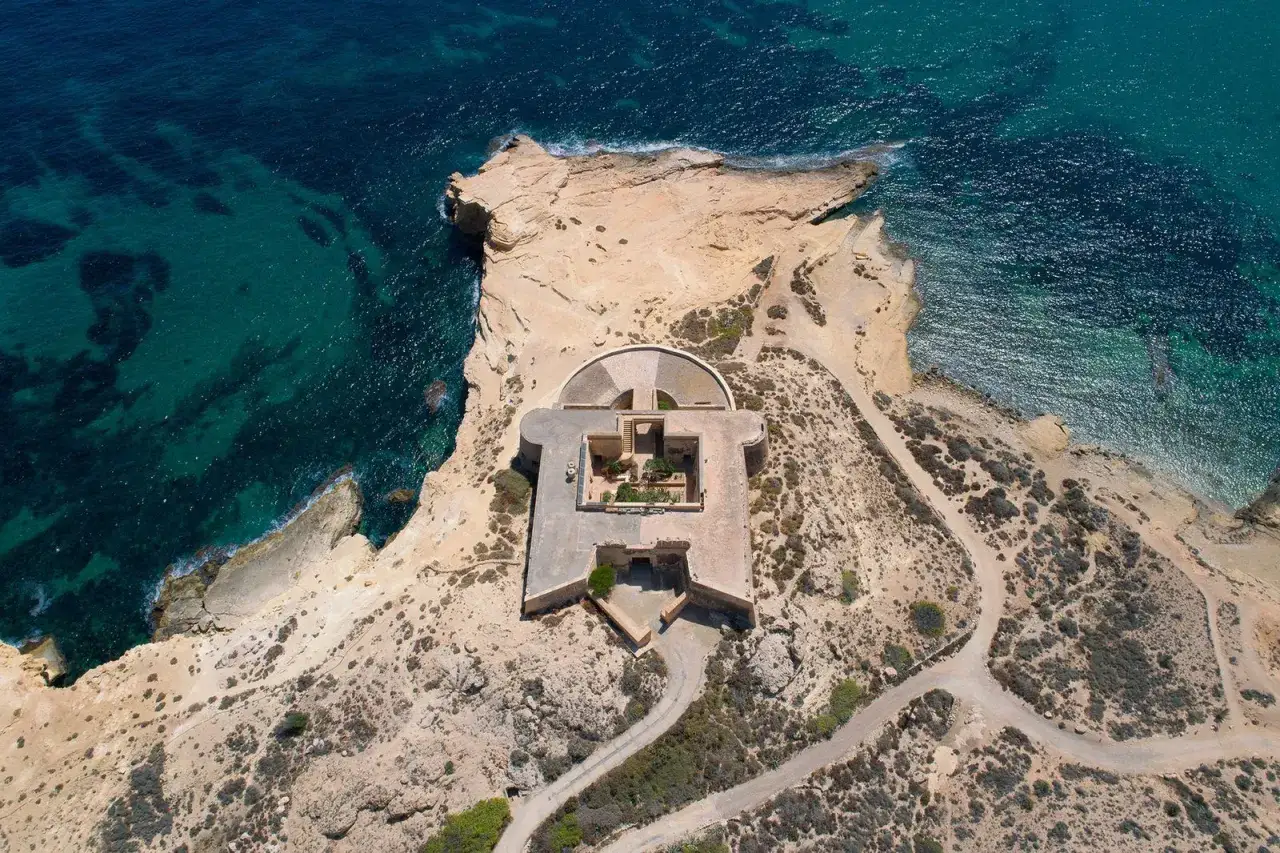 Fortaleza en el acantilado junto al mar turquesa, un lugar histórico que evoca el encanto de el playazo las negras.