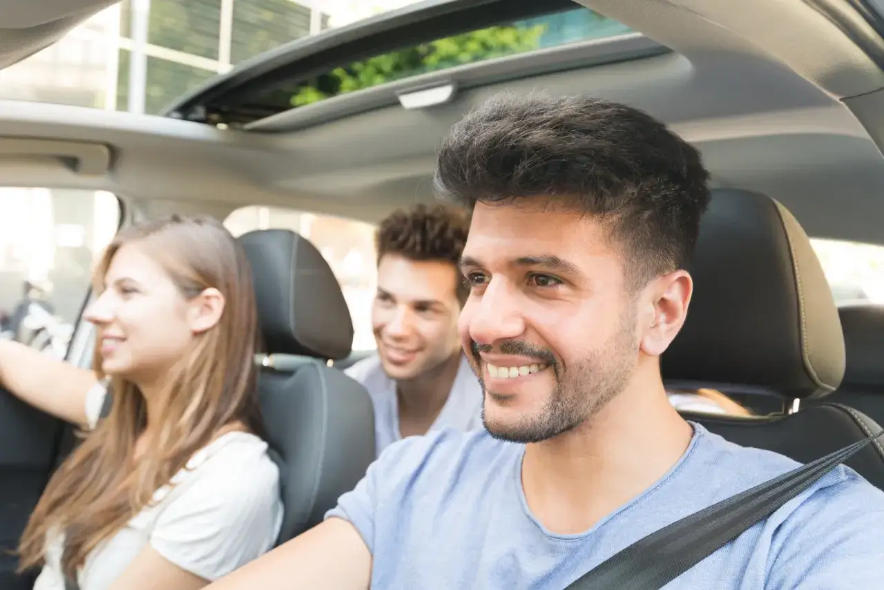 J&oacute;venes sonriendo en un coche. Los accidentes que sufren los j&oacute;venes suelen asociarse a distracciones, pero ellos disfrutan del viaje.