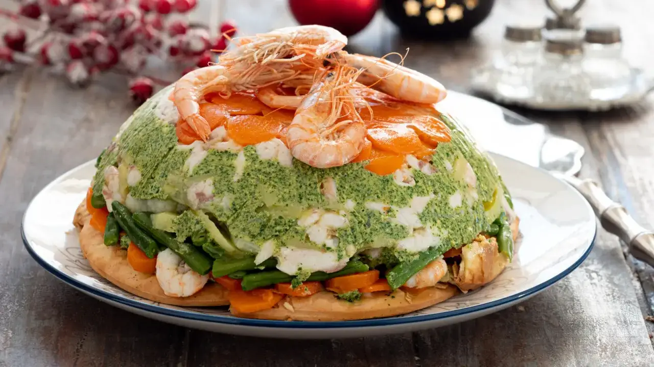 Un elaborato cappon magro, un capolavoro di pesce, verdure e gamberi, pronto per le feste.