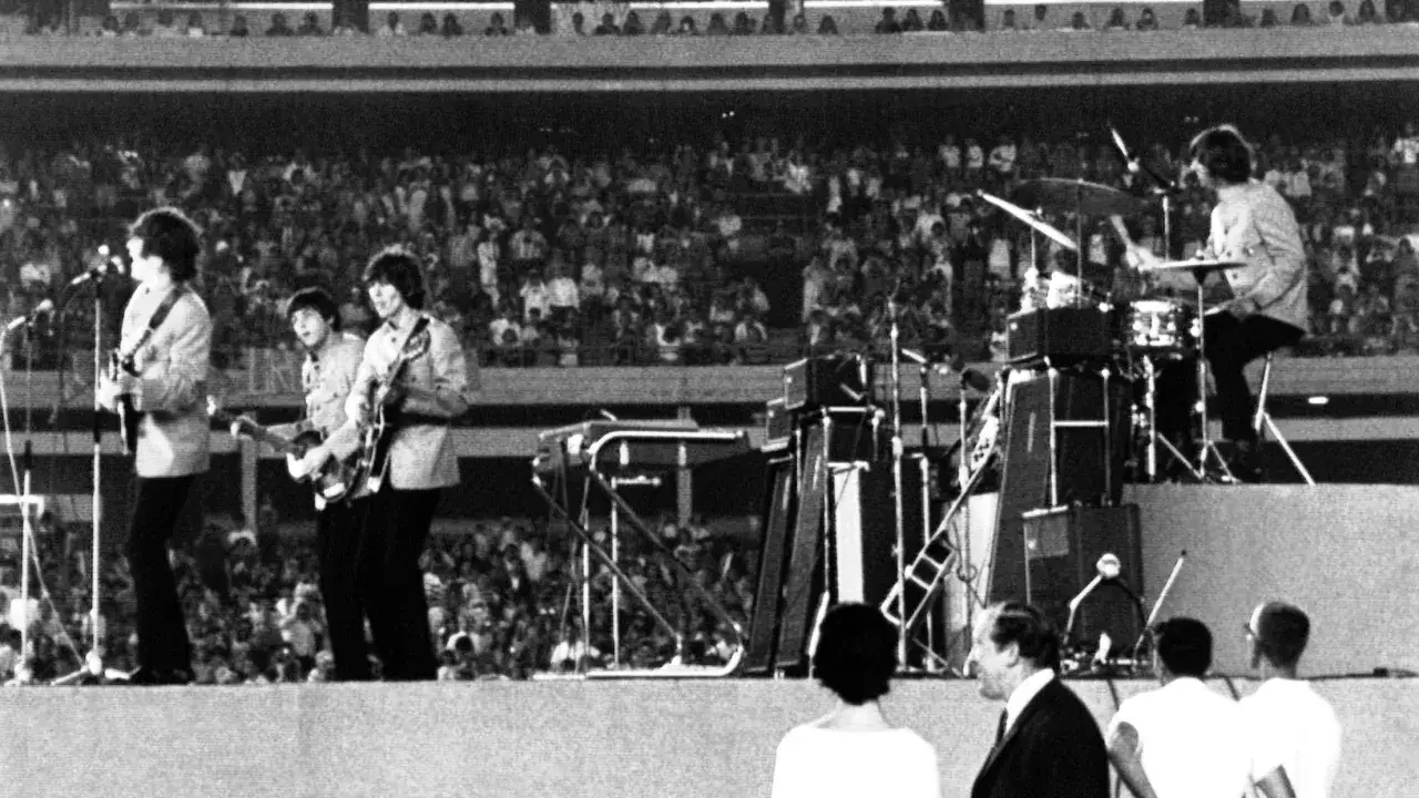The Beatles grają na żywo dla tłumu. Ringo Starr na perkusji, a pozostali członkowie zespołu z gitarami. Ciekawostki o ich koncertach są fascynujące!