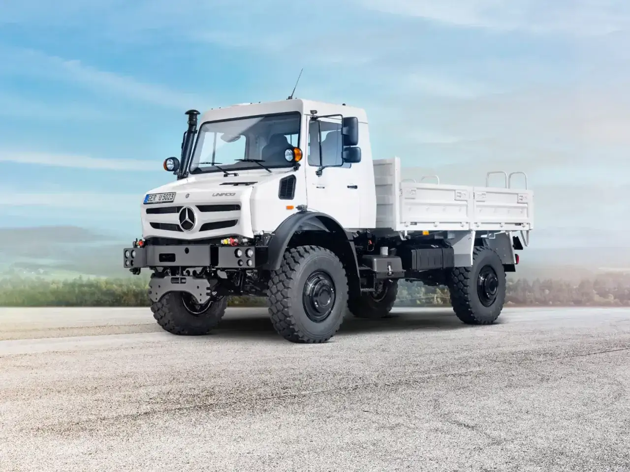 Biały Unimog z podwyższonym wlotem powietrza, gotowy na terenowe wyzwania.